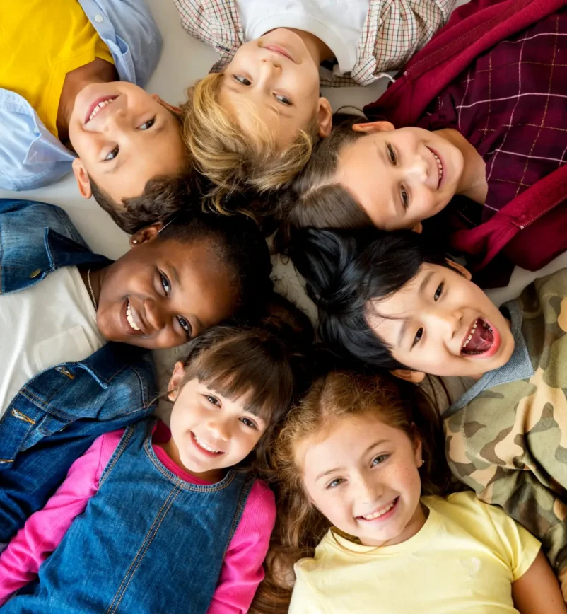 A group of primary schoolers lying on the ground and smiling